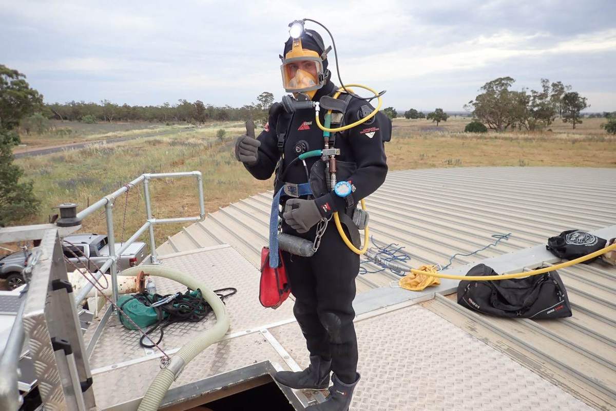 Diver kitted up and ready on the roof of a water reservoir