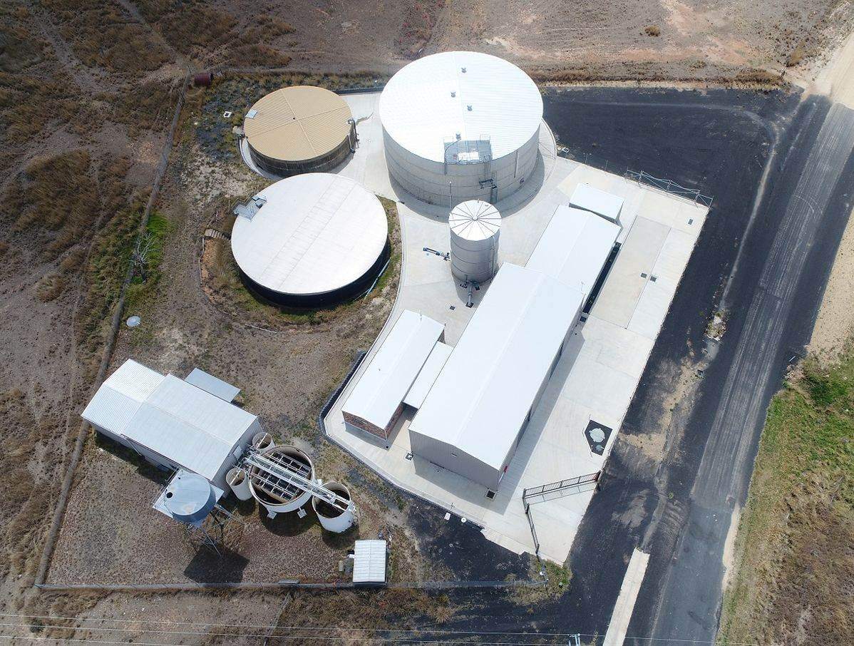Aerial view of a water treatment site with storage tanks and buildings
