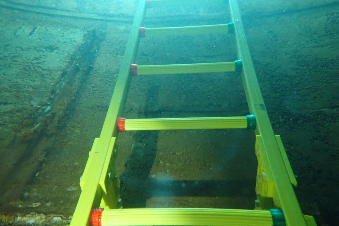 Replacement FRP ladder installed inside a water reservoir, photographed underwater