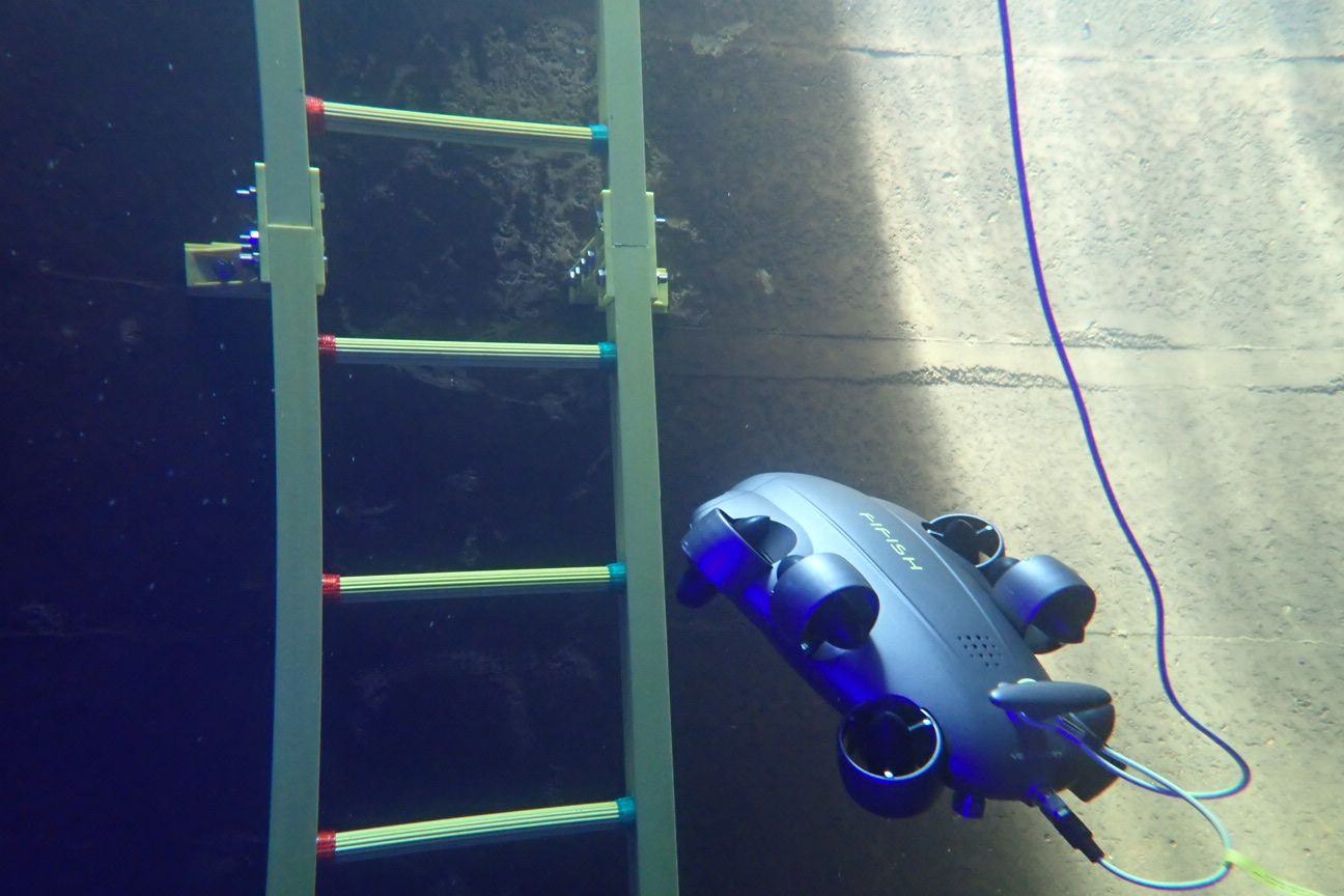 Remotely operated vehicle inspecting a ladder inside a water reservoir